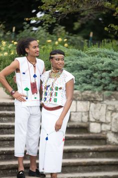 two people standing next to each other on some steps