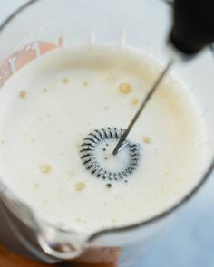 a blender filled with white liquid on top of a table