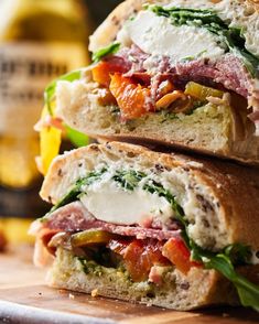 two sandwiches stacked on top of each other with cheese and meat in the middle, sitting on a cutting board