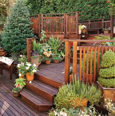 a wooden deck surrounded by potted plants and flowers