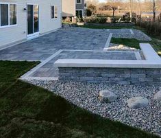 an outdoor patio area with rocks and grass