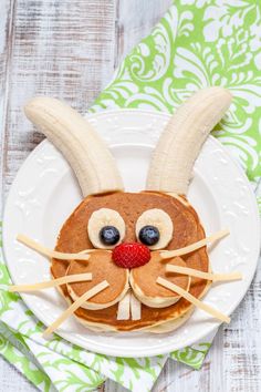 a close up of a plate of food with pancakes and bunny ears on it's face