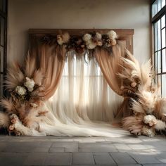 an arrangement of flowers and feathers on display in front of a window with sheer drapes