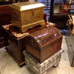 an elaborately decorated chest and box on display in a room with many other items