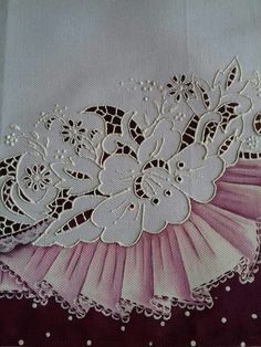 a close up of a piece of cloth with white lace on it and flowers in the center