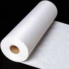 a roll of white paper sitting on top of a black surface