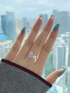 a woman's hand with green manies and a ring on top of it