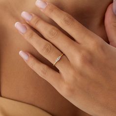 a woman's hand with a diamond ring on it