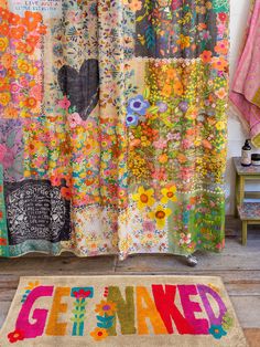 a colorful rug with the words get naked on it in front of a window covered by curtains