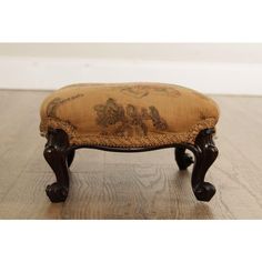 an antique foot stool with floral upholstered fabric