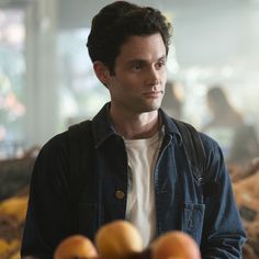 a man standing in front of some fruit