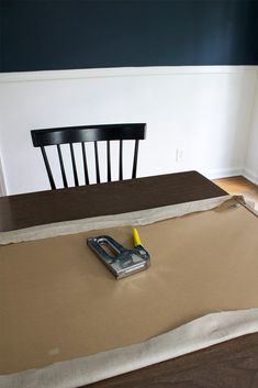 a table with a chair that has been taped down and a cordless phone laying on it