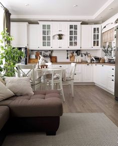 a living room filled with furniture next to a kitchen