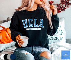 "UCLA Sweatshirt by varsitymerch * 50% Cotton; 50% Polyester * Medium - Heavy fabric * Soft fleecy lining * Air-jet spun yarn with a soft feel and reduced pilling * Ribbed knitted elastic collar * Unisex sizing - runs true to size All sweatshirts are made printed to order. Please expect slight color variances between the mock-up images on screen and the final printed design. *SIZES ARE UNISEX* - We'd suggest your usual size for a regular fit, or sizing up for a more relaxed fit. - Please see the size chart on the product images. -----Care Instructions----- Machine wash: warm (max 40C or 105F); Non-chlorine: bleach as needed; Tumble dry: medium heat; Do not iron; Do not dry clean. -----Shipping----- We offer free shipping to most countries! Below is an estimated shipping time: * Processing Ucla Sweatshirt, Senior Night, College Style, Workout Sweatshirt, Tour T Shirts, College Fashion, Black Sweater, Casual Tee, Lacrosse