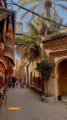 an alley way with shops and palm trees in the background, marraket, morocco