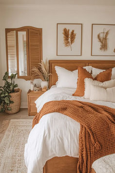 a bed with orange and white pillows in a bedroom next to two planters on either side of the bed