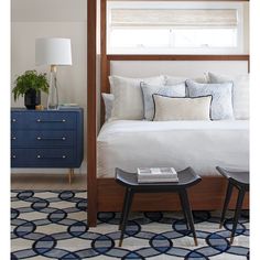 a bedroom with blue and white decor on the bed, nightstands and side tables