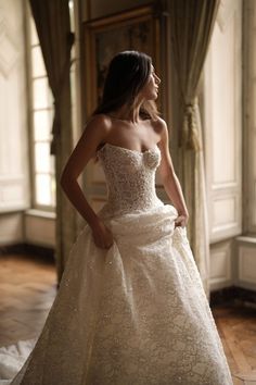 a woman in a wedding dress is posing for the camera