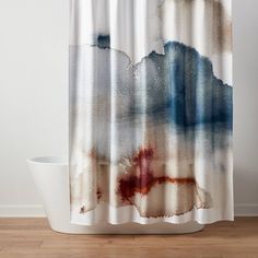 a shower curtain with an abstract painting on the outside and inside, in front of a wooden floor