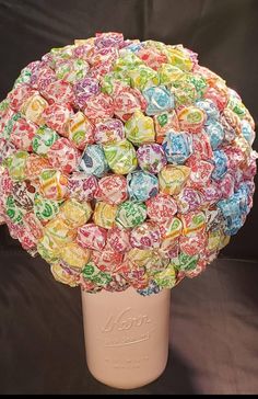 a vase filled with lollipops sitting on top of a table