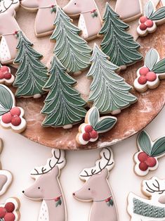 decorated christmas cookies on a platter with reindeers and trees