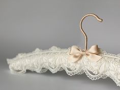 a white lace umbrella with a bow on it's handle and an attached hanger