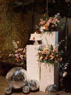 a cake with flowers on top and disco balls in the foreground next to it