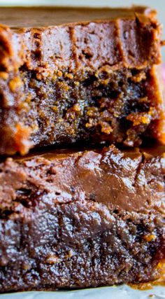 two pieces of chocolate brownie sitting on top of a white plate next to each other