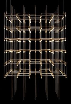 an abstract light sculpture with many lights on the top and bottom, against a black background