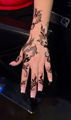 a woman's hand with hennap and flowers painted on it is shown