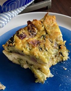 a piece of quiche sitting on top of a blue plate