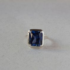 An Absolutely gorgeous Blue Sapphire corundum Gold ring. Featuring a Prong set 6.5 Carat 10 x 12 Blue Sapphire Gemstone. The color is simply amazing as well as the clarity, This is a Grade AAA Sapphire corundum Gemstone. When i saw the beauty of this gemstone i had to have it, I simply had to buy a few and make a few rings with them i could not escape its beauty! Each ring is hand made to your order from start to finish with the utmost attention to details, service and finish. We only have a few Blue Emerald Cut Ring With Bezel Setting, Blue Emerald Cut Rings With Bezel Setting, Modern Blue Radiant Cut Rings, Blue Topaz Ring With Square Cut, Blue Sapphire Ring With Square Cut, Rectangular Sapphire Ring With Accent Stones, Fine Jewelry Blue Sapphire Ring Square Cut, Blue Square Cut Sapphire Ring Fine Jewelry, Sapphire Square Cut Ring With Accent Stones