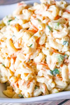 a white bowl filled with macaroni salad on top of a table