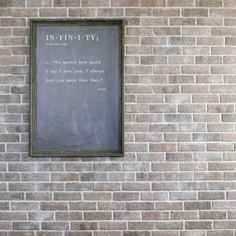 a brick wall with a framed sign on it