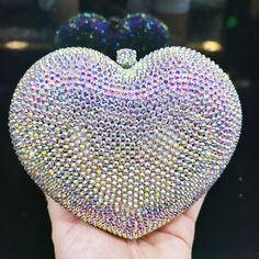 a hand holding a crystal heart shaped object