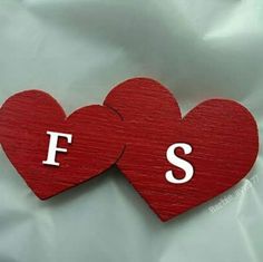 two wooden hearts with the letters f and s on them