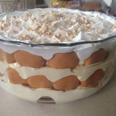 a close up of a cake in a glass dish on a table with white frosting