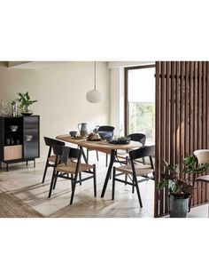 a dining room table and chairs in front of a sliding glass door with wooden slats