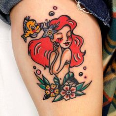 the little mermaid tattoo is on someone's leg