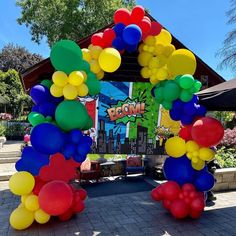 an arch made out of balloons on the sidewalk