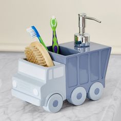 a toothbrush holder that is shaped like a train with wheels on the front and two toothbrushes in it