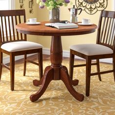 a wooden table with two chairs and a book on it