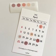 two calendars are sitting next to each other on a table with polka dot stickers