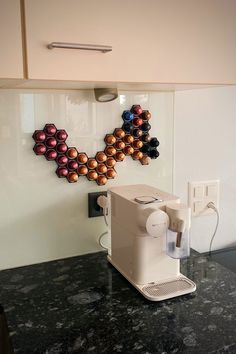 a coffee machine sitting on top of a counter next to a wall mounted magnets