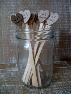 some wooden sticks in a glass jar with hearts on them and the words i love you