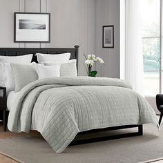 a bed in a bedroom with white and gray decor