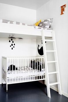 a white bunk bed sitting next to a black and white wall in a child's room