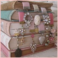 a stack of books sitting on top of each other next to a pile of jewelry