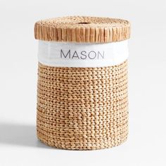 a woven basket with the word mason printed on it and a wooden lid sits in front of a white background