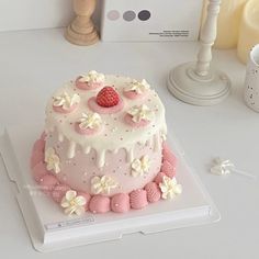 a cake with white frosting and pink decorations